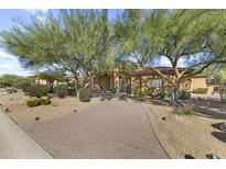 Beautiful home featuring desert landscaping, a private driveway and mature trees in a bright, sunny setting at 7335 E Quail Track Rd, Scottsdale, AZ 85266