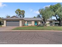 Charming single-story home with a well-manicured lawn, desert landscaping, and a two-car garage at 7533 N 8Th St, Phoenix, AZ 85020