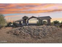 Charming single-story home featuring a desert landscape and a beautiful sunset backdrop at 8343 W Calle Lejos --, Peoria, AZ 85383