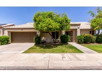 Charming single-story home with a well-manicured lawn, mature landscaping, and a two-car garage at 9002 W Caribbean Ln, Peoria, AZ 85381