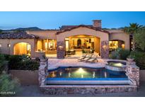 Stunning outdoor pool and spa with stone accents, perfect for relaxing and entertaining in a luxurious backyard setting at 11548 E Salero Dr, Scottsdale, AZ 85262