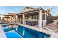 Inviting backyard featuring a pool, spa, covered patio, and outdoor seating area at 18080 W Spencer Dr, Surprise, AZ 85374