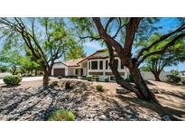 Beautiful single-story home with manicured landscaping, stone accents, and a terracotta tile roof, framed by mature trees at 35 E Secretariat Dr, Tempe, AZ 85284