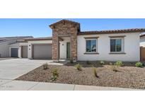 Charming single-story home featuring stone accents, a two-car garage, and desert landscaping at 37727 W Padilla St, Maricopa, AZ 85138