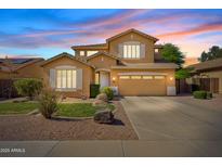 Charming two-story home with well-manicured lawn, desert landscaping, and an inviting facade at dusk at 4976 E Thunderbird Dr, Chandler, AZ 85249
