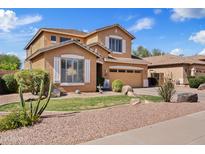 Charming two-story home features desert landscaping and an inviting facade under a clear blue sky at 4976 E Thunderbird Dr, Chandler, AZ 85249