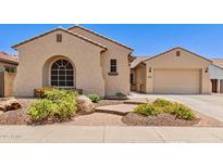 Beautiful home exterior with desert landscaping and a charming, arched window at 5541 W Desperado Way, Phoenix, AZ 85083