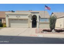 Charming single-story home with a two-car garage, landscaped front yard, and American flag at 6036 W Mescal St, Glendale, AZ 85304