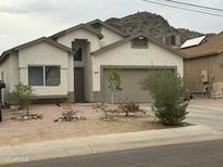 Single-Gathering home featuring neutral stucco, low-maintenance desert landscaping, and an attached two-car garage at 10006 N 7Th Pl, Phoenix, AZ 85020