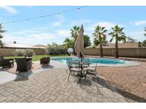 Inviting backyard featuring a refreshing pool, outdoor seating, and mature palm trees for a perfect oasis at 1406 E Jasper Dr, Chandler, AZ 85225