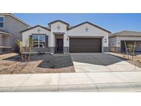 Charming single-Gathering home with a well-manicured front yard and a two-car garage, showcasing modern architecture at 17778 W Turquoise Ave, Waddell, AZ 85355