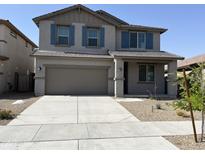 Two-story home showcasing a grey exterior, brown garage door, blue shutters and a well maintained lawn at 18361 W Jessie Ln, Surprise, AZ 85387
