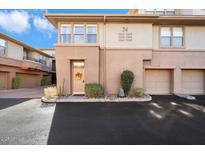 Close-up of a building entrance with a decorated door, landscaping, and multi-car garage at 19777 N 76Th N St # 2243, Scottsdale, AZ 85255