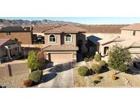 A charming two-story home featuring a terracotta tile roof and well-manicured landscaping at 19886 W Woodlands Ave, Buckeye, AZ 85326