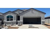 Newly built single-story home featuring gray stucco, a wide garage, and a picture window, awaiting final touches at 25478 W Graham Trl, Buckeye, AZ 85326