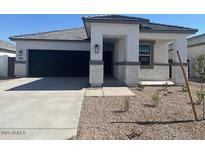 Charming single-story home featuring stone accents, a well-maintained front yard, and an attached two-car garage at 25481 W Graham Trl, Buckeye, AZ 85326