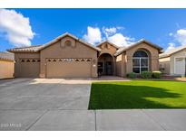 Charming single-story home with a well-manicured lawn and a three-car garage at 3350 E Rosemonte Dr, Phoenix, AZ 85050
