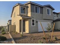 Two-story home boasts neutral stucco, dark trim, a two-car garage and desert landscaping at 3372 S 180Th Ln, Goodyear, AZ 85338