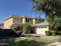 Stunning two-story home with mature landscaping, three-car garage and manicured lawn on a bright sunny day at 4109 E Sierra Madre Ave, Gilbert, AZ 85296