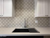Modern kitchen sink with white cabinets and stylish backsplash at 4228 N 81St St, Scottsdale, AZ 85251