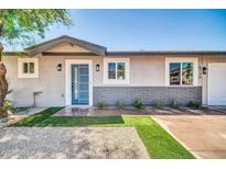 Charming home exterior boasting a blue front door, stone accents, and well-manicured artificial lawn at 5236 S 19Th Ave, Phoenix, AZ 85041