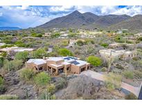 Desert home featuring sleek architectural design with a three-car garage and beautiful desert landscaping at 5892 E Carefree Mountain Dr, Carefree, AZ 85377