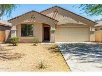 Charming single-story home with a low-maintenance desert-style front yard and attached two-car garage at 7365 W Magdalena Ln, Laveen, AZ 85339