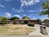Charming single-story home featuring a brick facade, well-manicured lawn, and an arched entryway at 1118 E Orangewood Ave, Phoenix, AZ 85020
