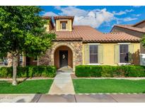 Charming home featuring a stone archway, lush green lawn and well-manicured hedges at 1134 S Lydia Ln, Gilbert, AZ 85296