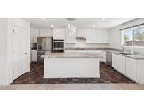 Stylish kitchen features white cabinetry, stainless steel appliances, and a granite countertop island at 12531 W Glenn Dr, Glendale, AZ 85307