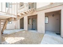 Exterior of a light beige apartment building with gravel landscaping and metal stairs at 1287 N Alma School Rd # 171, Chandler, AZ 85224