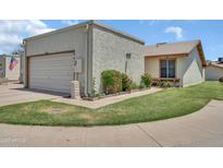 Home exterior featuring a detached garage, xeriscaping, and a well-maintained lawn at 13219 N 26Th Ave, Phoenix, AZ 85029