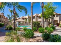 Community pool area surrounded by palm trees and lush landscaping at 1825 W Ray Rd # 1070, Chandler, AZ 85224