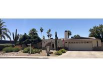 Charming single-story home featuring desert landscaping, an arched entryway, and a two-car garage at 2125 E Elmwood St, Mesa, AZ 85213