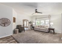 Bright living room boasts neutral palette, ceiling fan, plush carpeting, and large windows at 2233 E Behrend Dr # 162, Phoenix, AZ 85024