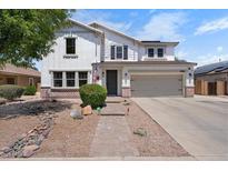 Charming two-story home featuring a well-manicured lawn, complemented by an attached two-car garage and traditional design elements at 2466 E Harrison Ct, Gilbert, AZ 85295