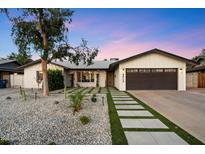 Charming home with a dark garage door, desert landscaping, and concrete walkway at 4613 S Rita Ln, Tempe, AZ 85282