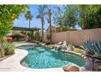 Inviting backyard pool surrounded by mature palm trees and meticulous landscaping at 758 S Lagoon Dr, Gilbert, AZ 85233