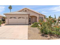 Charming single-story home featuring a well-maintained front yard and attached two-car garage at 9239 E Karen Dr, Scottsdale, AZ 85260