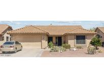 Charming single-story home with desert landscaping, a tile roof and attached two-car garage at 9814 W Menadota Dr, Peoria, AZ 85382