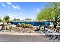Charming blue home featuring desert landscaping, complemented by an abundance of cacti and native vegetation at 1029 E Palo Verde Dr, Phoenix, AZ 85014