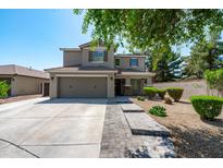 Charming two-story home showcasing a well-manicured lawn, complemented by a paved walkway and a spacious two-car garage at 12546 N 142Nd Ln, Surprise, AZ 85379