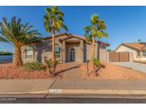 Charming home featuring desert landscaping with mature palm trees and a brick walkway at 14821 N 62Nd Ave, Glendale, AZ 85306