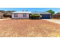 Charming single-story home featuring a gravel yard, solar panels, and an attached two-car garage at 1733 W Surrey Ave, Phoenix, AZ 85029