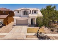 Charming two-story home featuring desert landscaping, a two-car garage, and neutral color scheme at 17433 W Holland Ln, Surprise, AZ 85388