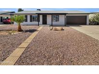 Charming single-story home with desert landscaping, brick walkway, and a dark-colored attached garage at 2127 W Marco Polo Rd, Phoenix, AZ 85027