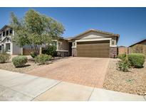 Charming single-story home featuring a brick driveway, desert landscaping, and a two-car garage at 26141 N 133Rd Ave, Peoria, AZ 85383