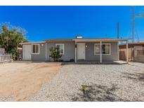 Charming single-story home with gravel landscaping, covered porch, and freshly painted gray exterior at 3913 W Sherman St, Phoenix, AZ 85009