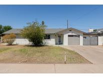 Charming single-story home featuring a well-maintained front yard, driveway, and attached garage at 5802 N 61St Dr, Glendale, AZ 85301