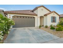 Charming single-Gathering home featuring a tile roof, desert landscaping, and attached two-car garage at 5897 N 195Th Dr, Litchfield Park, AZ 85340
